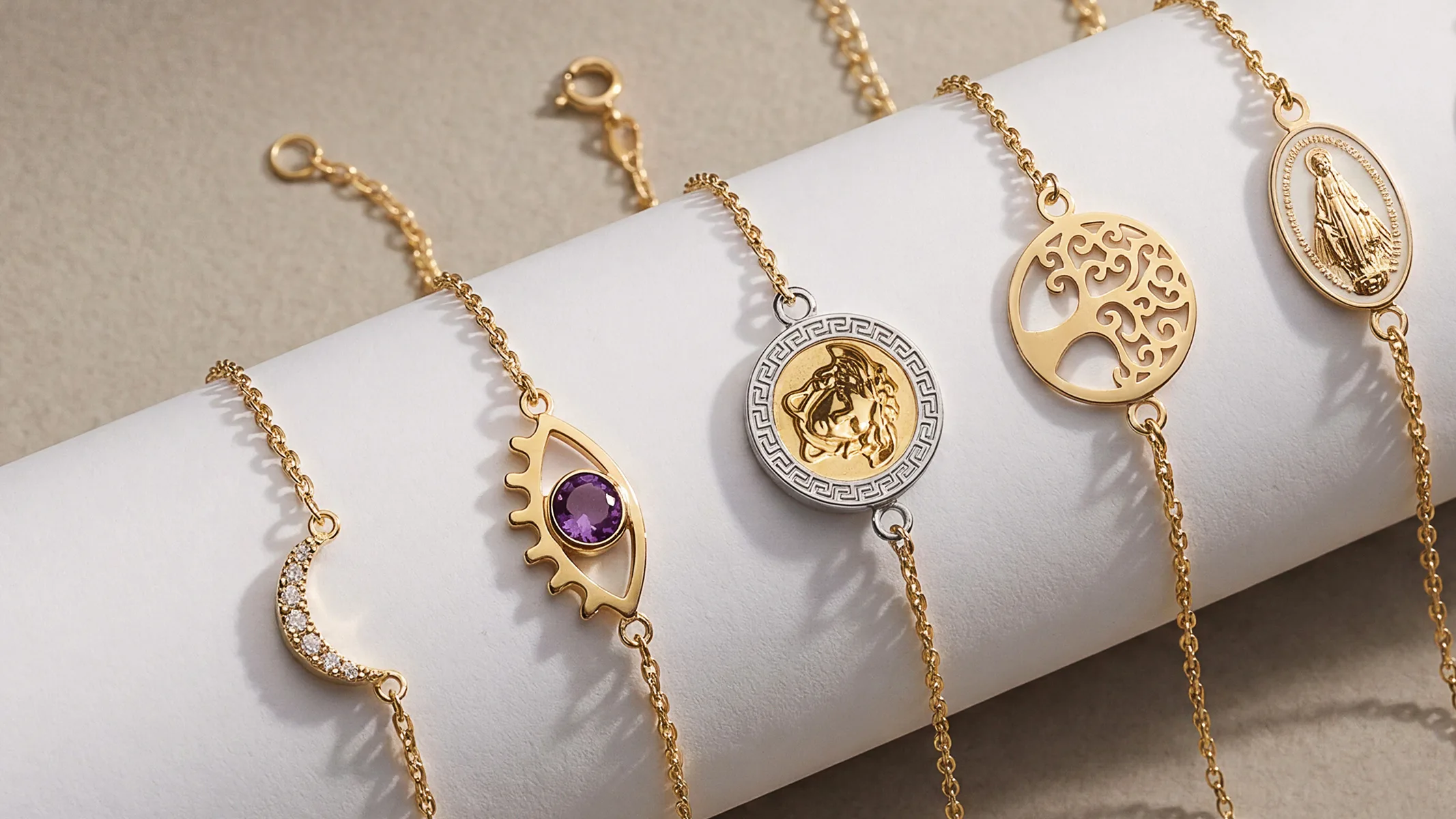Cinq bracelets en or avec breloques variées médaille lune oeil et arbre de vie
